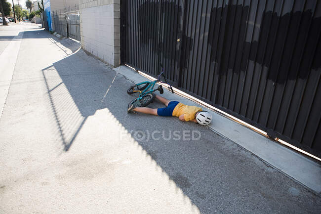 Раненый велосипедист лежит на тротуаре — стоковое фото