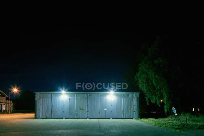 Гараж здание с прожекторами ночью — стоковое фото