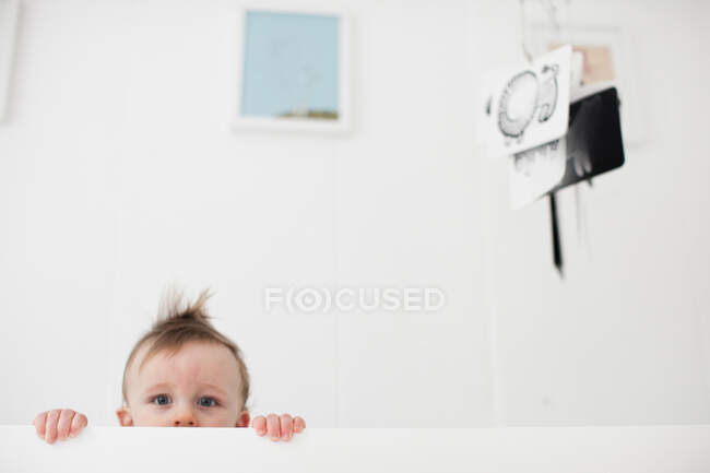 Portrait of baby boy staring from crib — Stock Photo