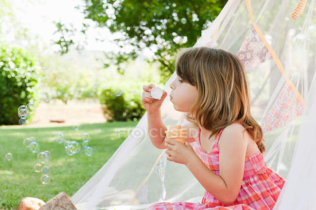 Jeune fille avec baguette à bulles — Photo de stock
