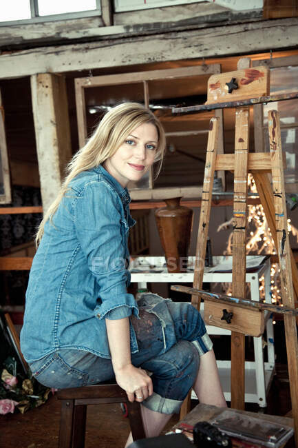 Взрослая женщина сидит в мастерской художника, портрет — стоковое фото