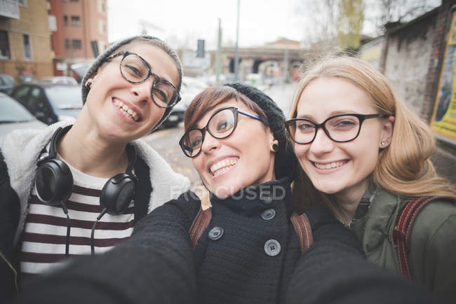 Tres hermanas tomando selfie en la calle - foto de stock