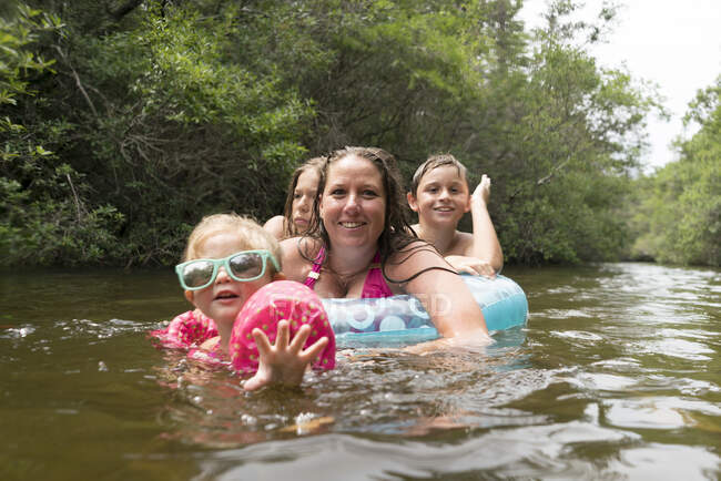 Madre e hijos con anillo inflable en el lago, Niceville, Florida, Estados Unidos - foto de stock