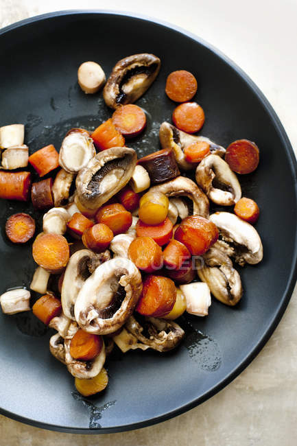 Cenouras cozidas no vapor e cogumelos na panela, vista superior — Fotografia de Stock
