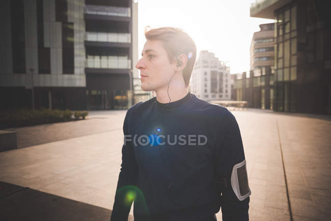 Молодий чоловік бігун готується до бігу на міській площі — стокове фото