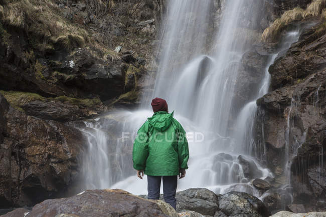 Hombre mirando cascada, River Toce, Premoselló, Verbania, Piedmonte, Italia - foto de stock
