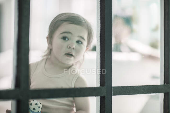 Кейптаун, Южная Африка, маленький ребенок, смотрящий в окно — стоковое фото