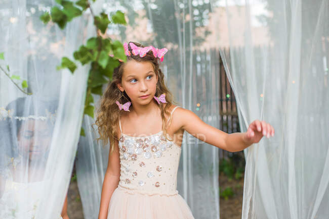 Portrait of young girl dressed as fairy, walking through sheer material — Stock Photo