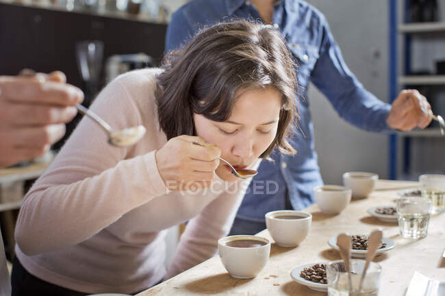 Degustatori di caffè sorseggiando caffè con cucchiaio — Foto stock