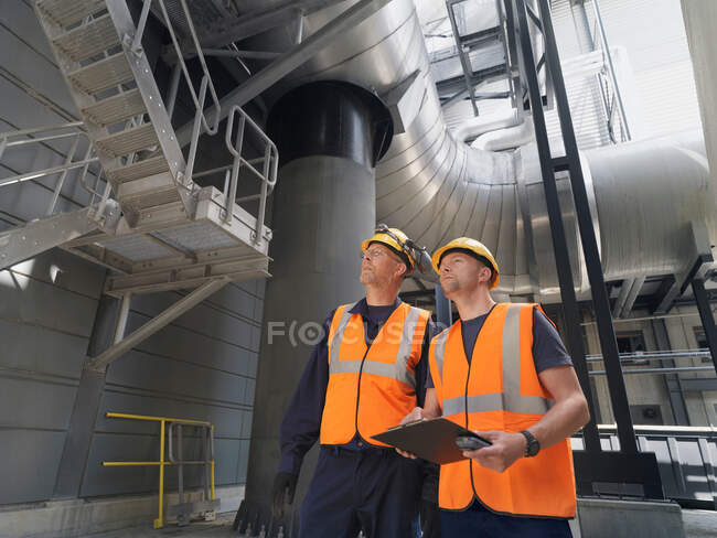 Arbeiter untersuchen Maschinen in Fabrik — Stockfoto