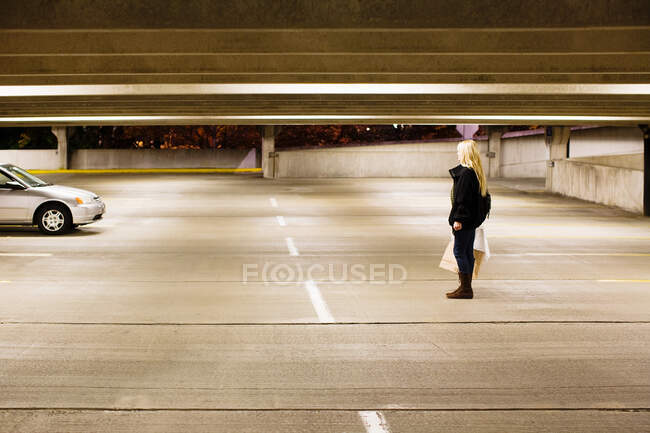 Mulher sozinha no estacionamento — Fotografia de Stock
