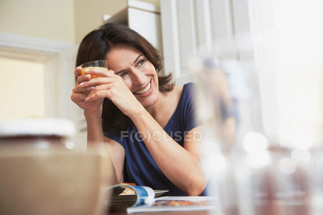 Жінка тримає скло на кухні — стокове фото