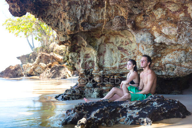 Jovem casal olhando para fora da caverna da praia, Taiba, Ceará, Brasil — Fotografia de Stock
