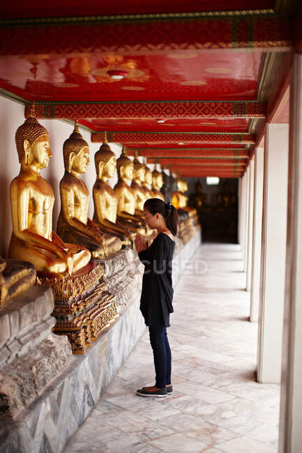 Woman praying in front of monument — Stock Photo