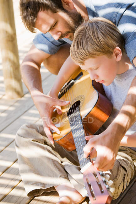 Pai e filho tocando guitarra — Fotografia de Stock