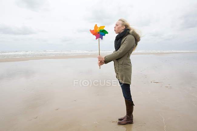 Jovem mulher por mar com pinwheel — Fotografia de Stock