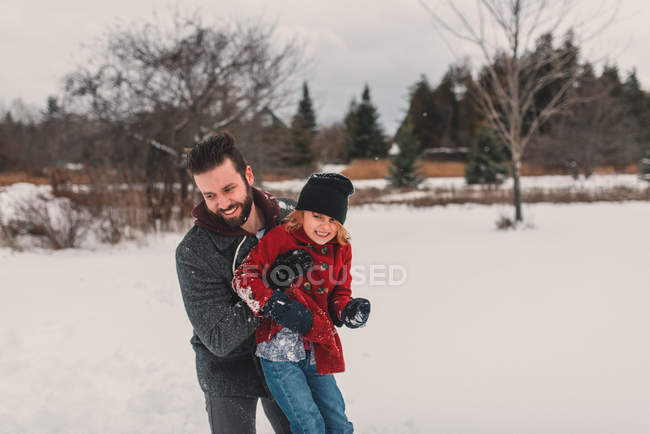 Отец и дочь играют в снегу — стоковое фото