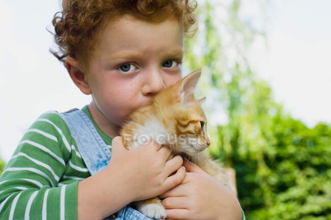 Un ragazzo con in braccio un gattino — Foto stock