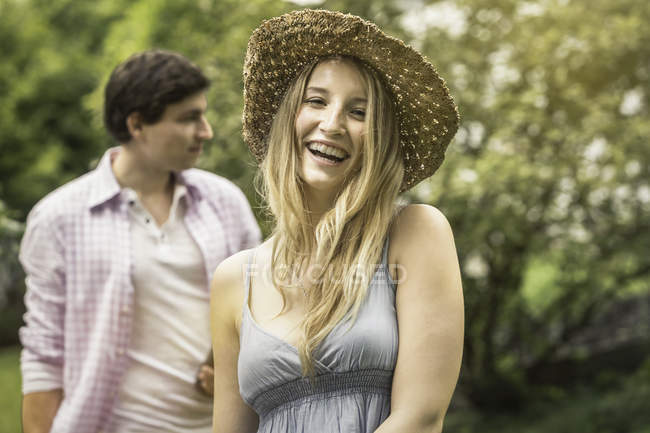 Молода жінка в солом'яному капелюсі сміється, портрет — стокове фото