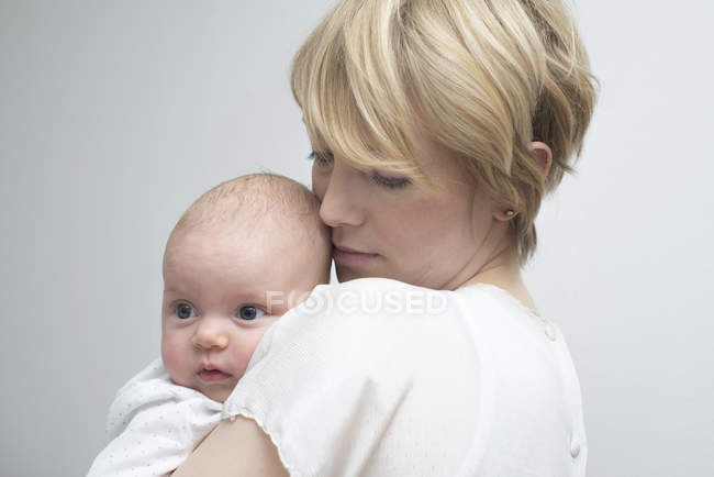 Madre che porta la bambina contro il petto — Foto stock