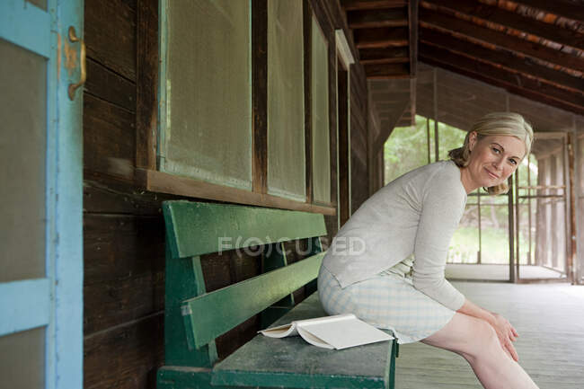 Mujer madura sentada en el banco - foto de stock