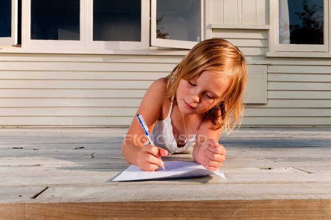 Girl on porch, drawing a picture — Stock Photo