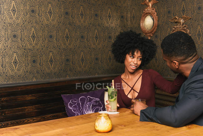 Paar sitzt in Kneipe am Tisch — Stockfoto