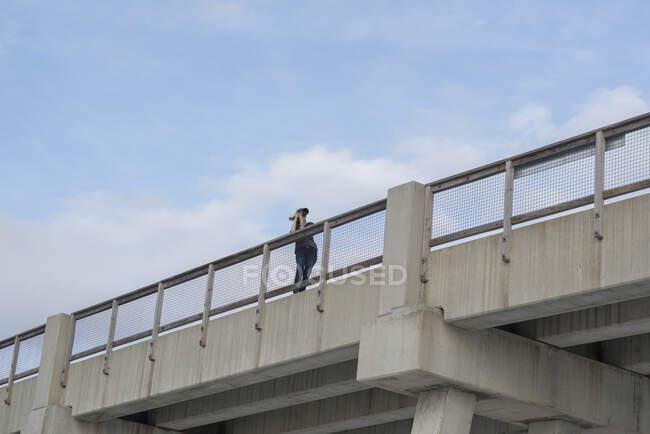 Vue en angle bas d'une femme sur un pont prenant des photos, Destin, Golfe du Mexique, États-Unis — Photo de stock