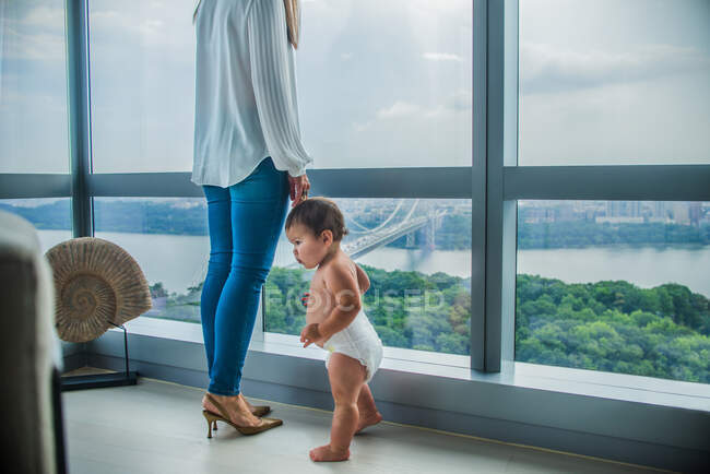 Madre e figlio alla finestra con vista baia — Foto stock
