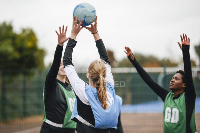 Female netball teams throwing ball on netball court — Stock Photo