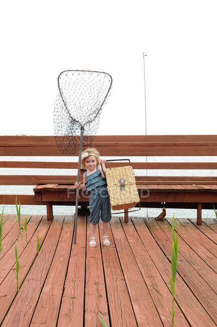 Girl carrying net and picnic basket — Stock Photo