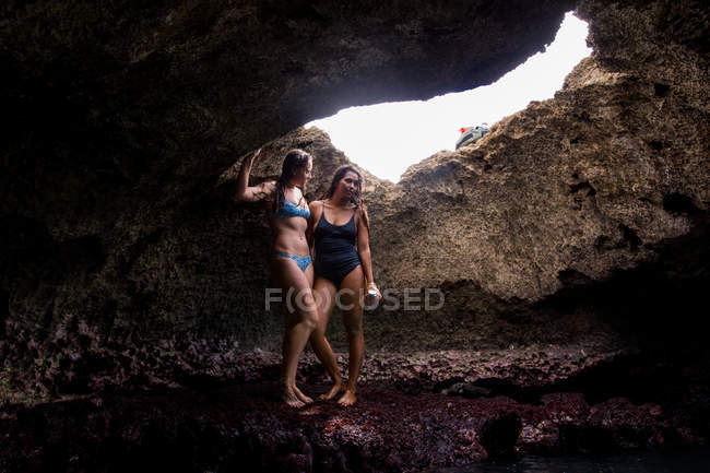Друзья в пещере в купальниках, Оаху, Гавайи, США — стоковое фото