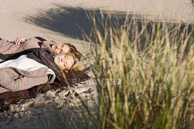 Mujer napping on beach - foto de stock
