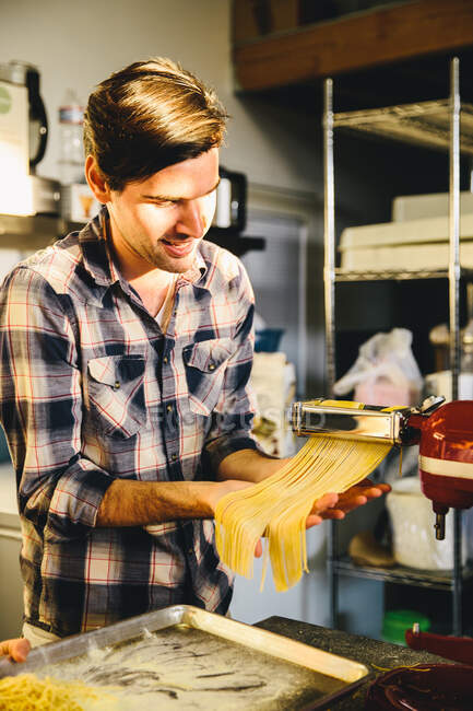 Student slicing dough with pasta maker — Stock Photo