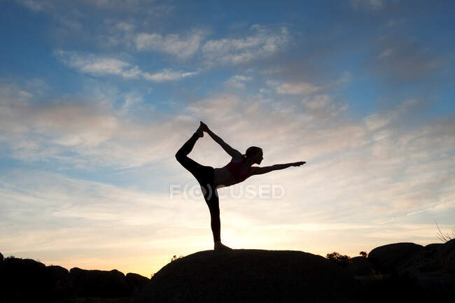 Mujer joven en pose de bailarina en el desierto, silueta - foto de stock