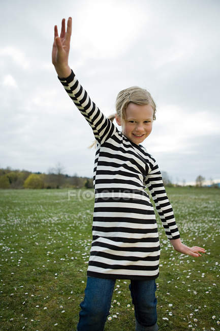 Mädchen mit erhobenen Armen auf der Wiese — Stockfoto