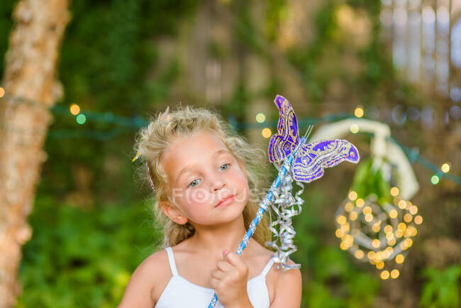 Portrait of young girl holding butterfly wand — Stock Photo