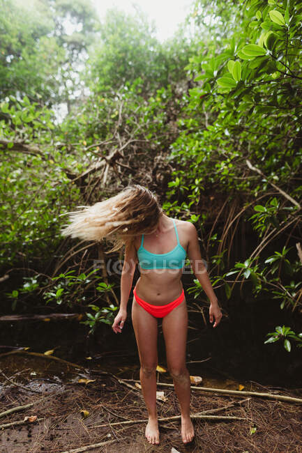 Молодая женщина в бикини в лесу бросает волосы назад, Оаху, Гавайи, США — стоковое фото