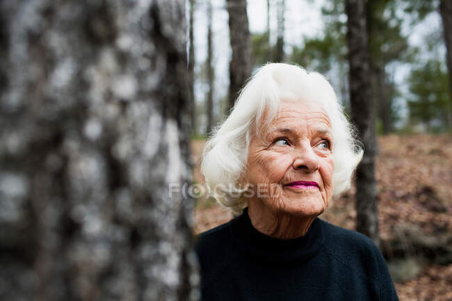 Portrait de femme âgée regardant loin dans la forêt — Photo de stock