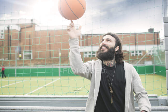 Metà uomo adulto girando pallacanestro sul dito — Foto stock
