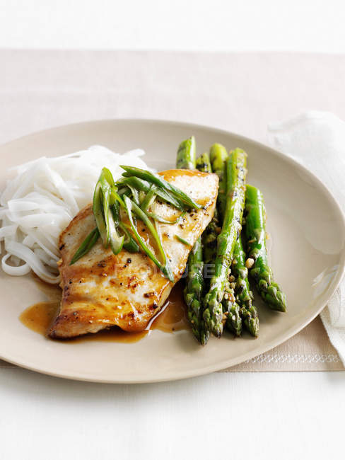 Plate of chicken, asparagus and noodles — Stock Photo