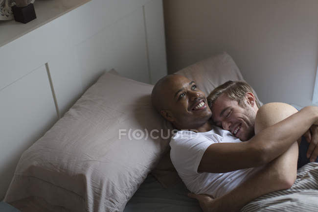 Casal masculino deitado na cama juntos, abraçando — Fotografia de Stock