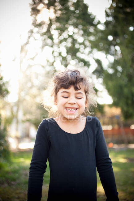 Chica joven sonriendo en el jardín - foto de stock
