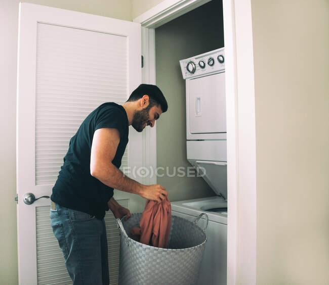 Homem lavando roupa em casa — Fotografia de Stock