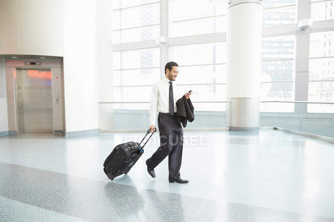 Businessman pulling wheeled suitcase — Stock Photo