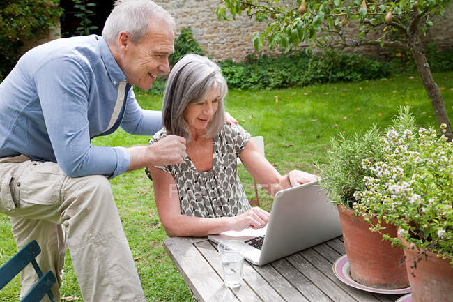 Mature couple using laptop — Stock Photo