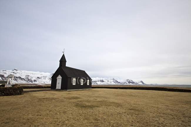 Vista sulla chiesa di Budir e sulle montagne innevate — Foto stock