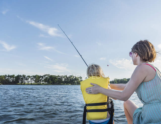 Mother and son wearing life jacket fishing — Stock Photo