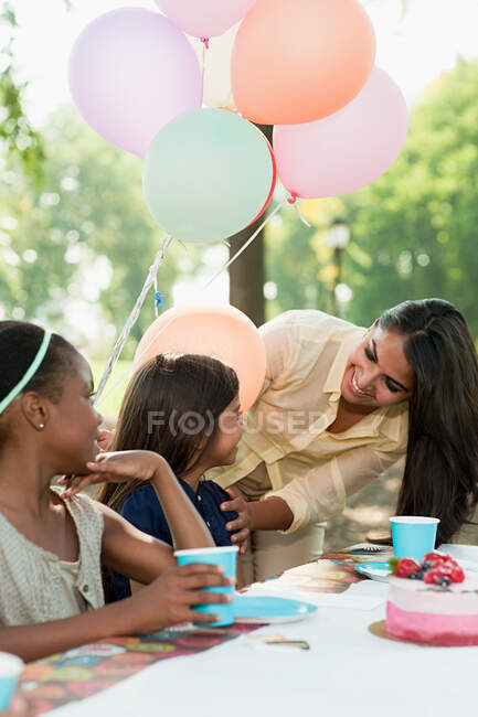 Niños en fiesta de cumpleaños con pastel de cumpleaños - foto de stock