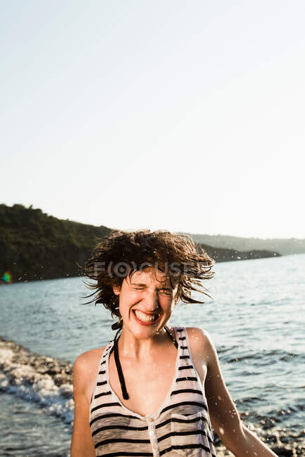 Lächelnde Frau spielt am Strand — Stockfoto